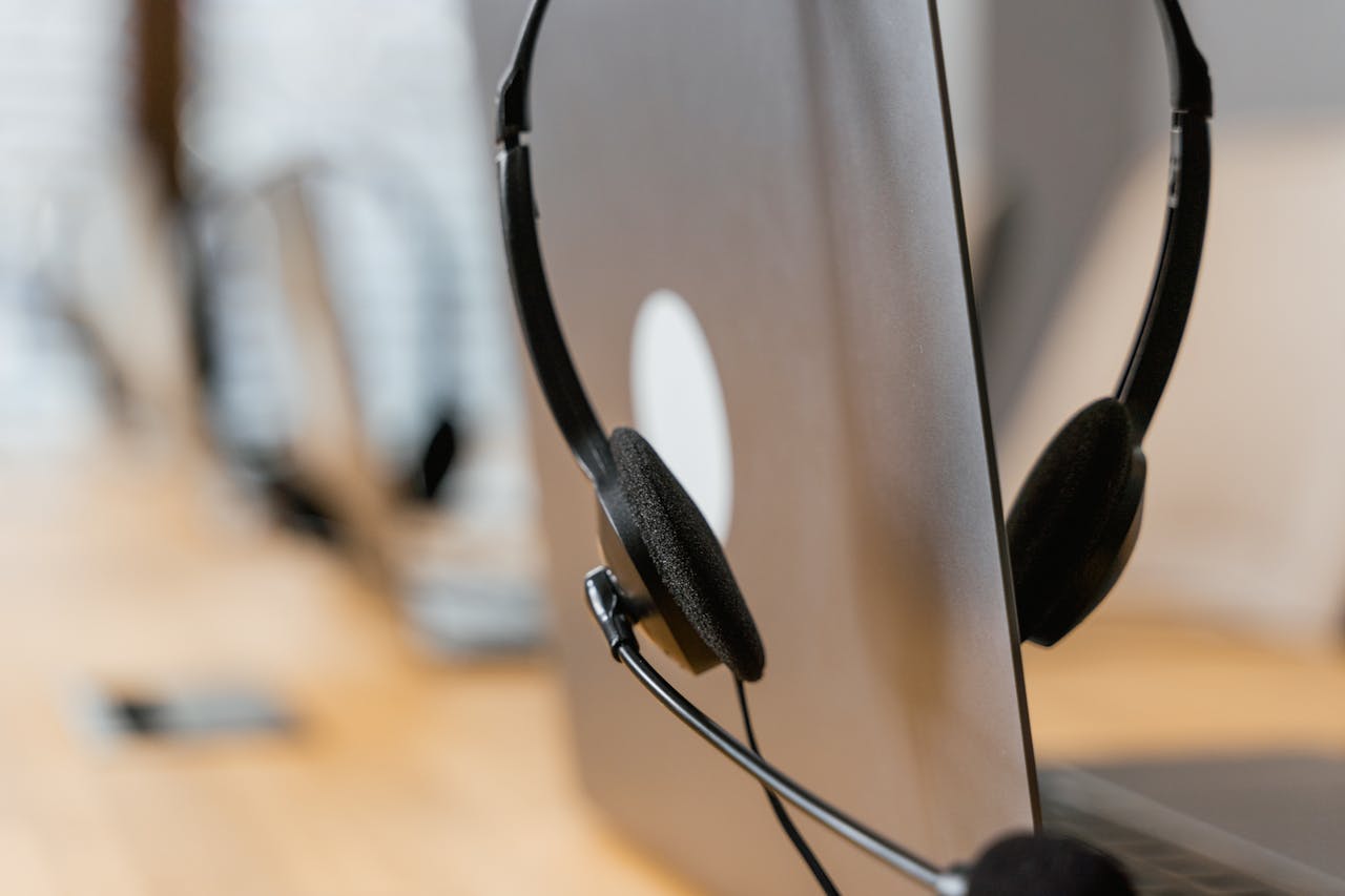 our-story Close-up of a headset resting on a laptop, symbolizing efficient work environment technology.