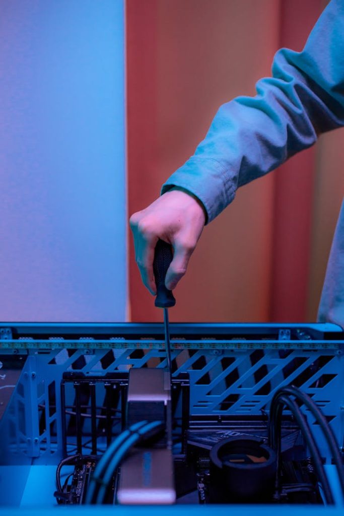 pexels-photo-7859349 Close-up of hand using screwdriver inside PC tower, illustrating technology repair.